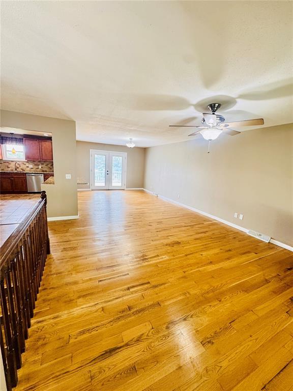 1202 S Mildred Ave, Salem, MO 65560 - unfurnished living room featuring light wood-type flooring, ceiling fan, and baseboards