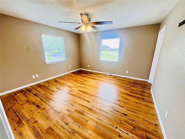 1202 S Mildred Ave, Salem, MO 65560 - unfurnished room with healthy amount of natural light, wood finished floors, a ceiling fan, baseboards, and a textured ceiling