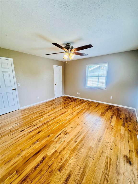 1202 S Mildred Ave, Salem, MO 65560 - unfurnished room featuring light wood-type flooring, a ceiling fan, a textured ceiling, and baseboards
