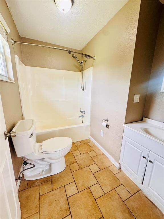 1202 S Mildred Ave, Salem, MO 65560 - bathroom featuring toilet, shower / bath combination, vanity, baseboards, and a textured ceiling