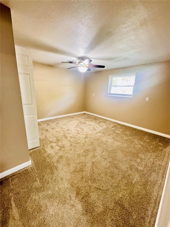 1202 S Mildred Ave, Salem, MO 65560 - unfurnished room with carpet, a textured ceiling, baseboards, and a ceiling fan