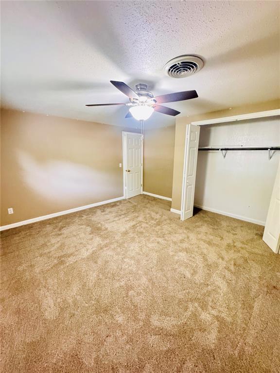 1202 S Mildred Ave, Salem, MO 65560 - unfurnished bedroom with carpet flooring, baseboards, a ceiling fan, a textured ceiling, and a closet