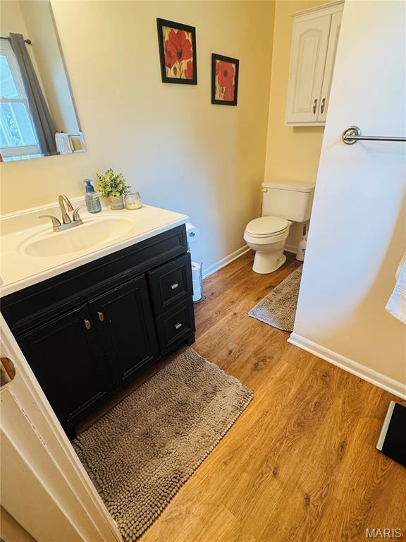 414 Hillcrest Dr, Sullivan, MO 63080 - half bathroom with toilet, vanity, wood finished floors, and baseboards