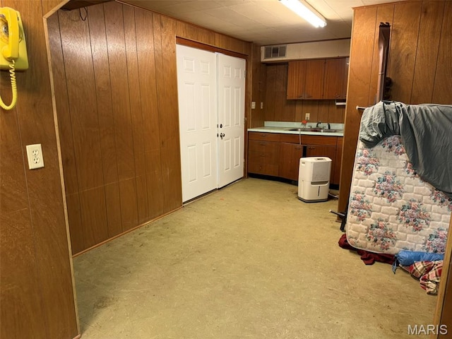 414 Hillcrest Dr, Sullivan, MO 63080 - kitchen with wooden walls, light countertops, a sink, brown cabinetry, and light colored carpet