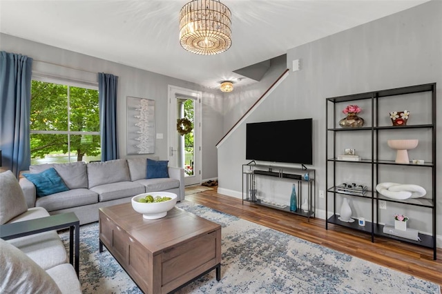3481 New Town Lake Dr, Saint Charles, MO 63301 - living room featuring wood finished floors, baseboards, stairway, and a chandelier