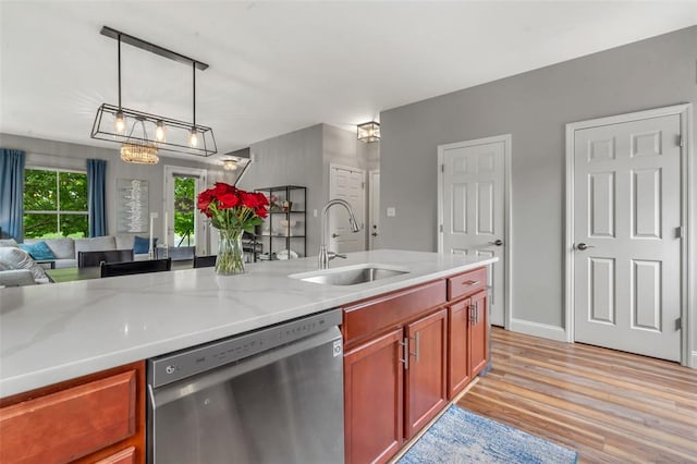 3481 New Town Lake Dr, Saint Charles, MO 63301 - kitchen with dishwasher, a sink, open floor plan, light wood-style floors, and light stone counters