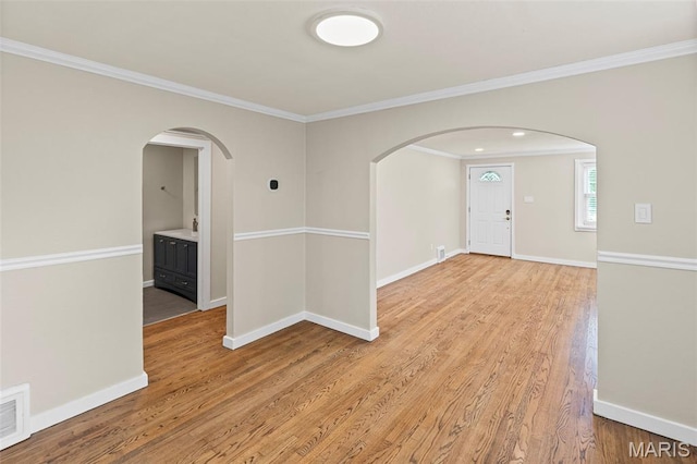 6446 Old Collinsville Rd, Ofallon, IL 62269 - empty room featuring arched walkways, crown molding, and light wood-type flooring