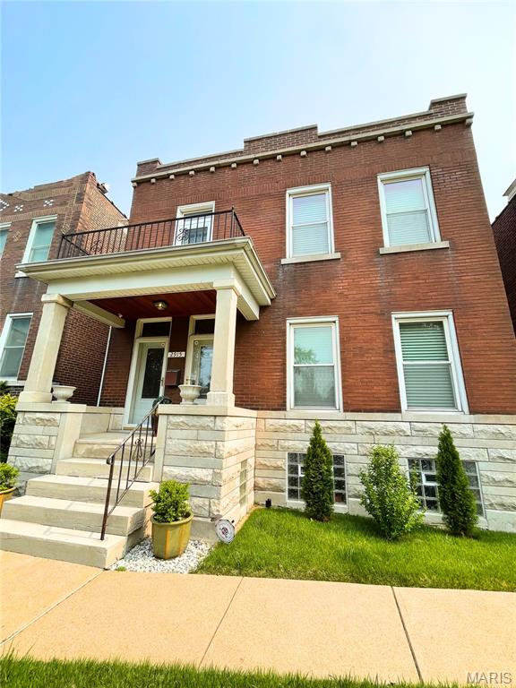 2915 Meramec St, Saint Louis, MO 63118 - view of front of property featuring a balcony, stone siding, brick siding, and covered porch