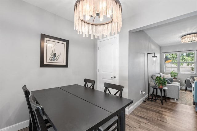 1491 Bobolink Pl, Brentwood, MO 63144 - dining area featuring a chandelier, baseboards, and wood finished floors