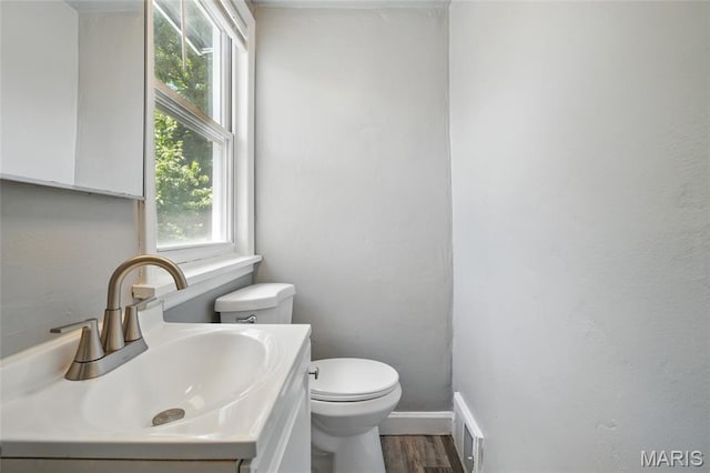 41 S Dellwood Ave, Saint Louis, MO 63135 - half bath featuring toilet, vanity, wood finished floors, and baseboards