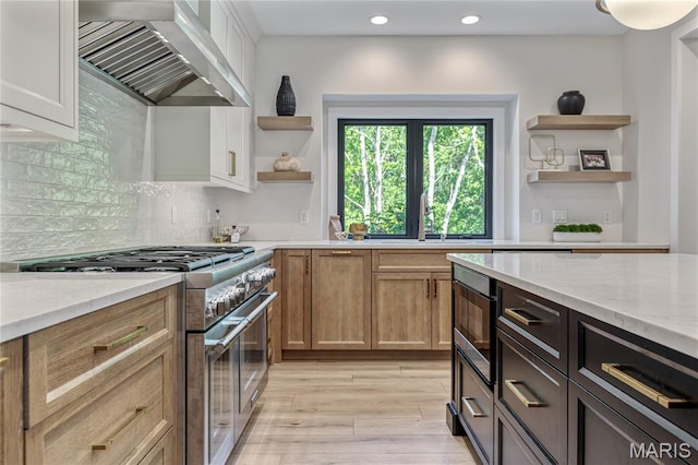 100 Enclave Terrace Ct, Weldon Spring, MO 63304 - kitchen with open shelves, wall chimney exhaust hood, appliances with stainless steel finishes, light wood-type flooring, and light stone countertops