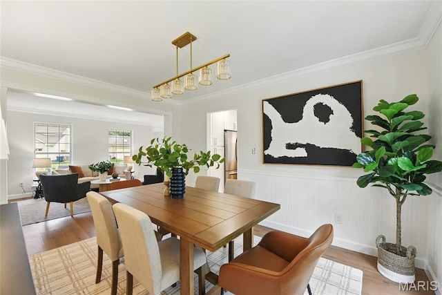 973 Kylemore Dr, Ballwin, MO 63021 - dining area featuring crown molding, light wood finished floors, and wainscoting