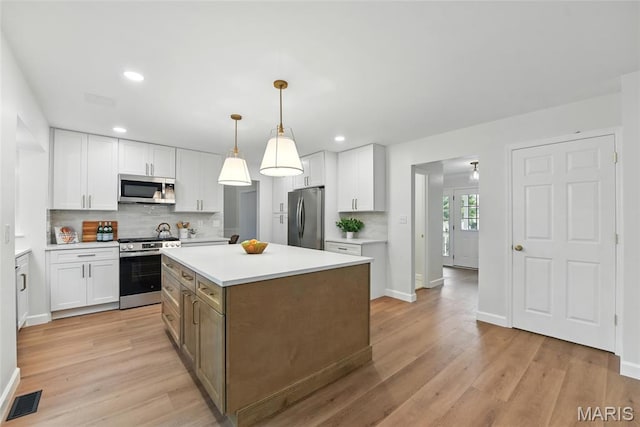 973 Kylemore Dr, Ballwin, MO 63021 - kitchen featuring appliances with stainless steel finishes, white cabinets, backsplash, light wood-type flooring, and recessed lighting
