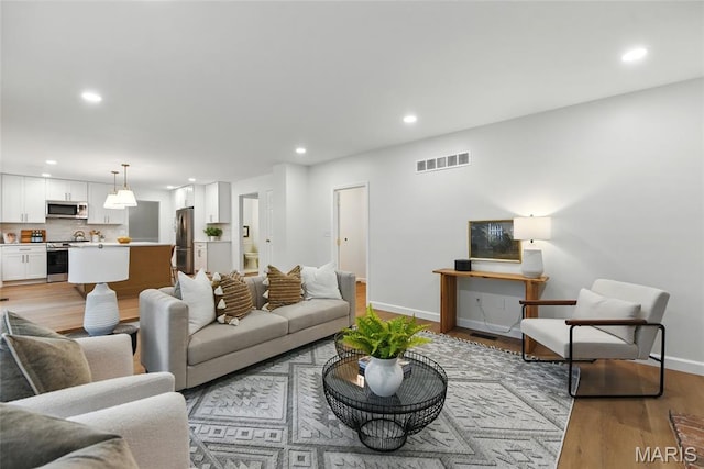 973 Kylemore Dr, Ballwin, MO 63021 - living area with light wood-type flooring, recessed lighting, and baseboards