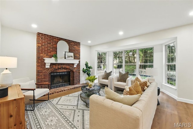 973 Kylemore Dr, Ballwin, MO 63021 - living room featuring wood finished floors, plenty of natural light, recessed lighting, a brick fireplace, and baseboards