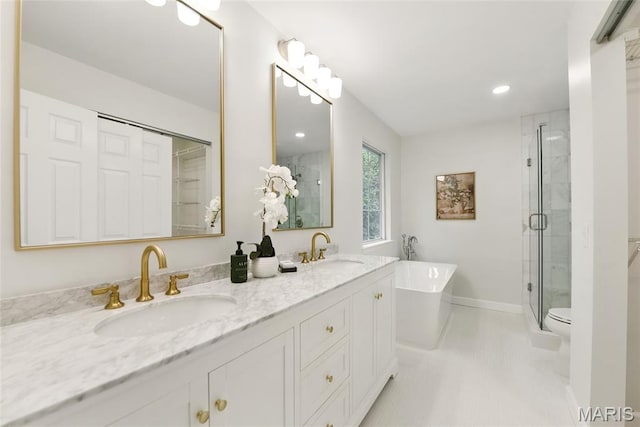 973 Kylemore Dr, Ballwin, MO 63021 - full bathroom featuring double vanity, a soaking tub, a shower stall, toilet, and baseboards
