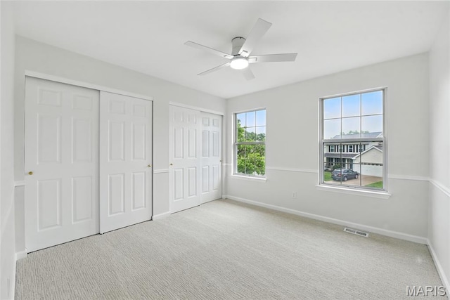 973 Kylemore Dr, Ballwin, MO 63021 - unfurnished bedroom with two closets, baseboards, carpet floors, and ceiling fan