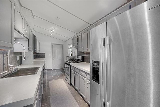 2831 Dunkirk Dr, Saint Louis, MO 63119 - kitchen with stainless steel appliances, under cabinet range hood, tasteful backsplash, gray cabinets, and lofted ceiling