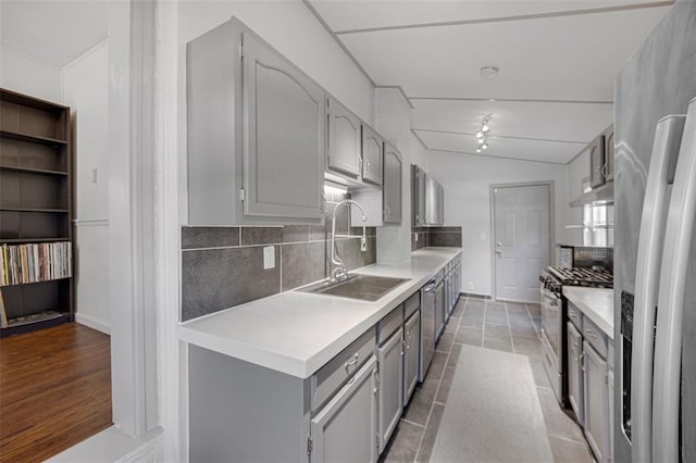 2831 Dunkirk Dr, Saint Louis, MO 63119 - kitchen featuring appliances with stainless steel finishes, gray cabinets, a sink, under cabinet range hood, and backsplash
