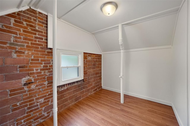 2831 Dunkirk Dr, Saint Louis, MO 63119 - additional living space featuring vaulted ceiling, wood finished floors, baseboards, and brick wall