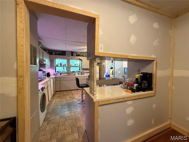 929 Race St, Thayer, MO 65791 - kitchen with washer / dryer, ventilation hood, light countertops, and a peninsula