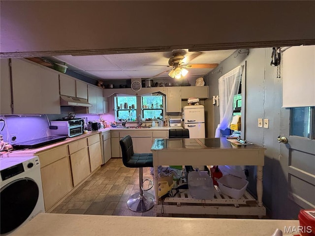 929 Race St, Thayer, MO 65791 - kitchen with washer / dryer, under cabinet range hood, a ceiling fan, refrigerator, and light countertops
