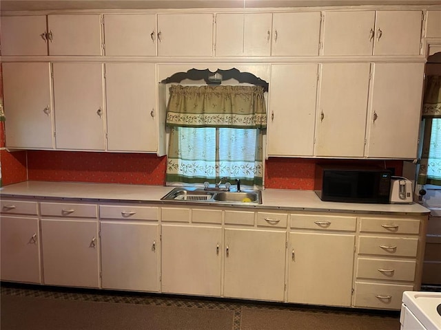 500 E 10th St, Salem, MO 65560 - kitchen featuring black microwave, a sink, light countertops, and white cabinetry
