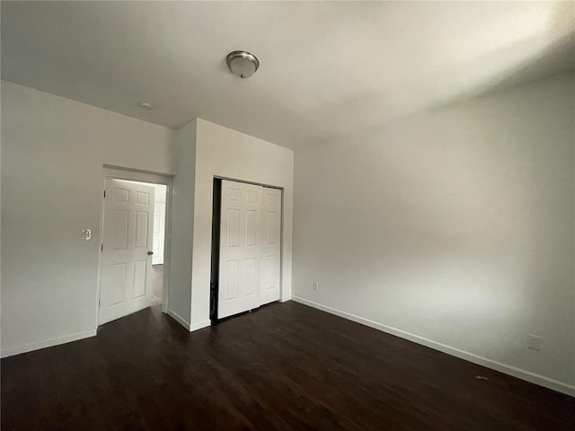 3819 Nebraska Ave, Saint Louis, MO 63118 - unfurnished bedroom with dark wood-type flooring, baseboards, and a closet