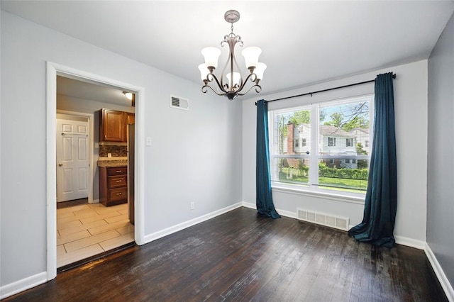 7448 Ahern Ave, Saint Louis, MO 63130 - unfurnished room featuring a chandelier, wood finished floors, and baseboards