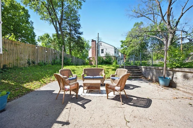 7448 Ahern Ave, Saint Louis, MO 63130 - fenced backyard featuring a patio, an outdoor hangout area, and stairs