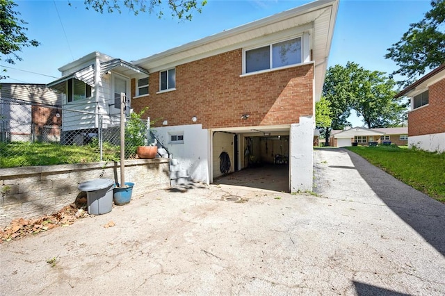 7448 Ahern Ave, Saint Louis, MO 63130 - rear view of property with a garage, driveway, and brick siding