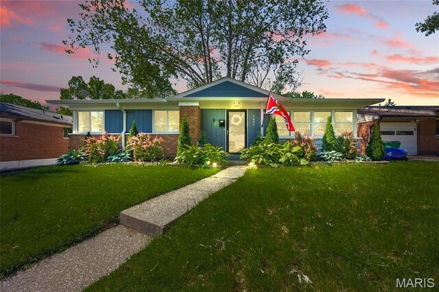 7448 Ahern Ave, Saint Louis, MO 63130 - ranch-style home featuring a front lawn, brick siding, and an attached garage