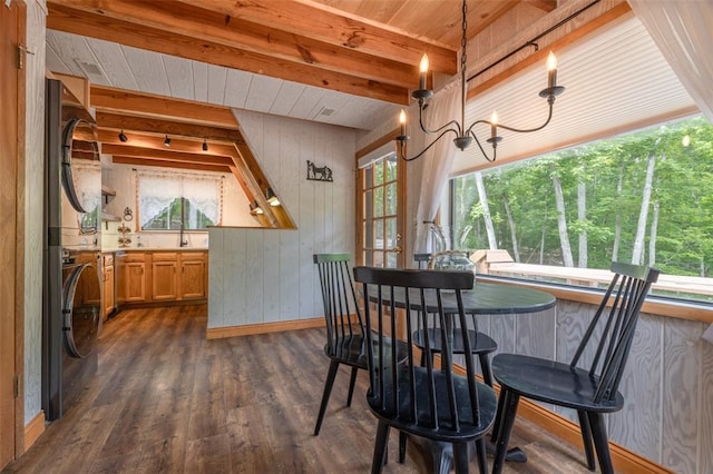 1129 Mitten Ridge Dr, Innsbrook, MO 63390 - dining space with estacked washer and dryer, wood ceiling with exposed beams, wooden walls, baseboards, and dark wood-style floors