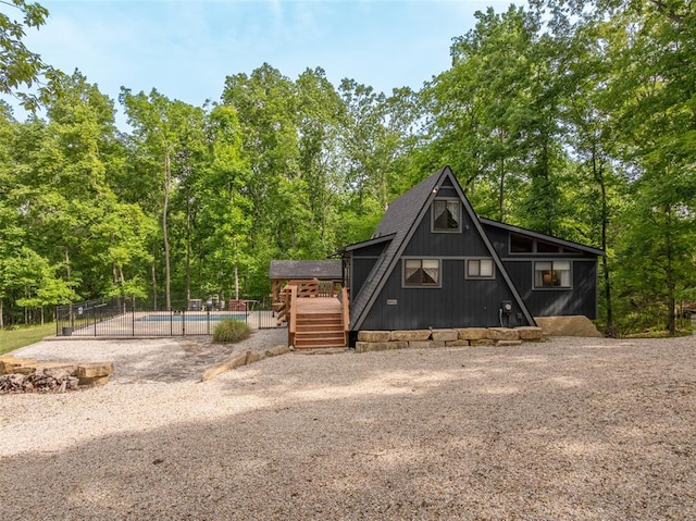 1129 Mitten Ridge Dr, Innsbrook, MO 63390 - a-frame home featuring a deck, driveway, and view of wooded area