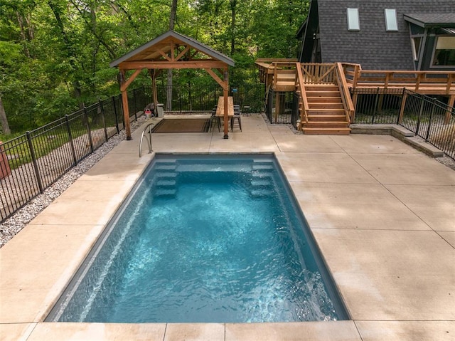 1129 Mitten Ridge Dr, Innsbrook, MO 63390 - view of swimming pool with a gazebo, a deck, a patio area, and view of wooded area