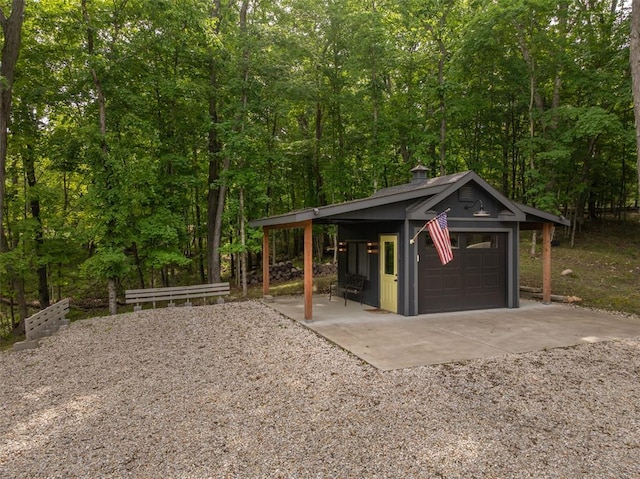 1129 Mitten Ridge Dr, Innsbrook, MO 63390 - view of front of property featuring a garage, gravel driveway, a chimney, and a forest view