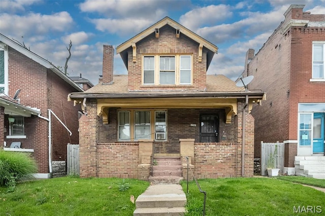 4545 Alice Ave, Saint Louis, MO 63115 - view of front facade with covered porch, brick siding, a front yard, and a shingled roof