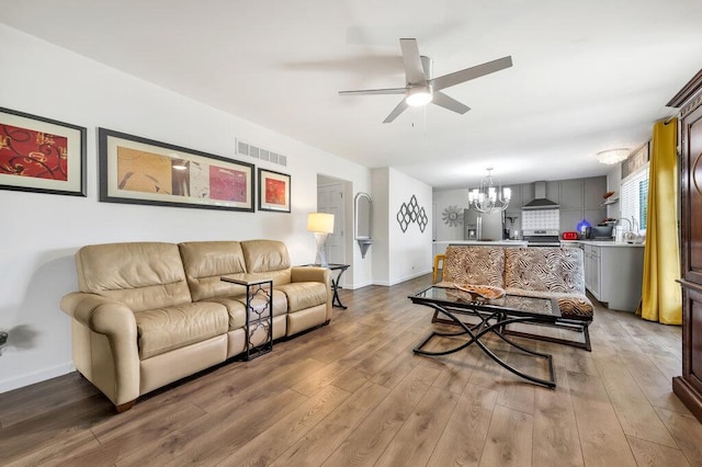 11943 Brookington Dr, Bridgeton, MO 63044 - living room featuring ceiling fan, a chandelier, wood finished floors, and baseboards