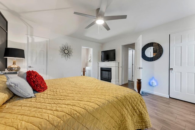 11943 Brookington Dr, Bridgeton, MO 63044 - bedroom featuring wood finished floors, baseboards, a glass covered fireplace, and a ceiling fan