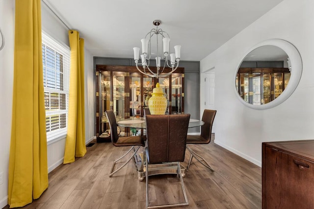 11943 Brookington Dr, Bridgeton, MO 63044 - dining space with a chandelier, wood finished floors, and baseboards