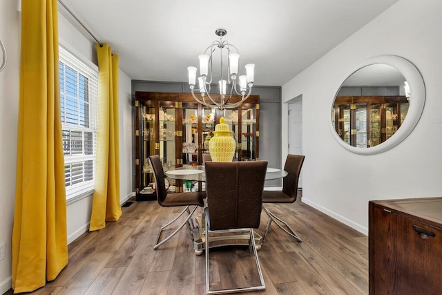 11943 Brookington Dr, Bridgeton, MO 63044 - dining room featuring a chandelier, wood finished floors, and baseboards