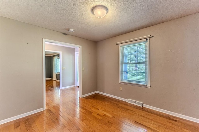 21509 Rockwell Dr, Lebanon, MO 65536 - unfurnished room featuring light wood finished floors, a textured ceiling, a smoke detector, and baseboards