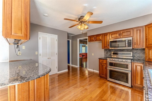 21509 Rockwell Dr, Lebanon, MO 65536 - kitchen featuring appliances with stainless steel finishes, light wood-style flooring, and brown cabinetry