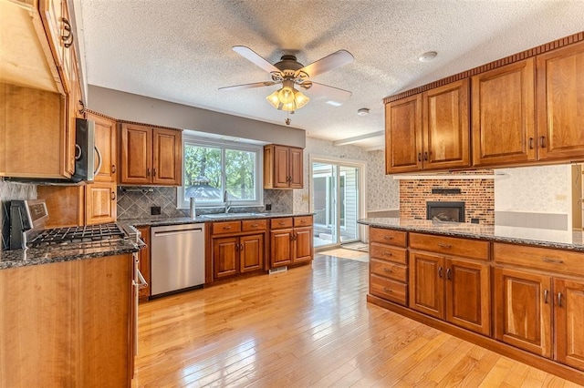 21509 Rockwell Dr, Lebanon, MO 65536 - kitchen featuring appliances with stainless steel finishes, brown cabinetry, a textured ceiling, a ceiling fan, and light wood-type flooring