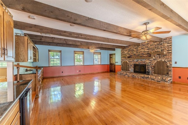 21509 Rockwell Dr, Lebanon, MO 65536 - unfurnished living room with a ceiling fan, light wood-type flooring, plenty of natural light, beam ceiling, and a textured ceiling