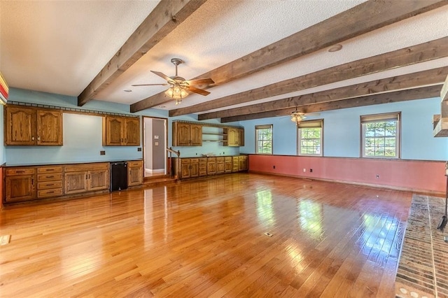 21509 Rockwell Dr, Lebanon, MO 65536 - unfurnished living room featuring ceiling fan, light wood-style floors, beam ceiling, and baseboards