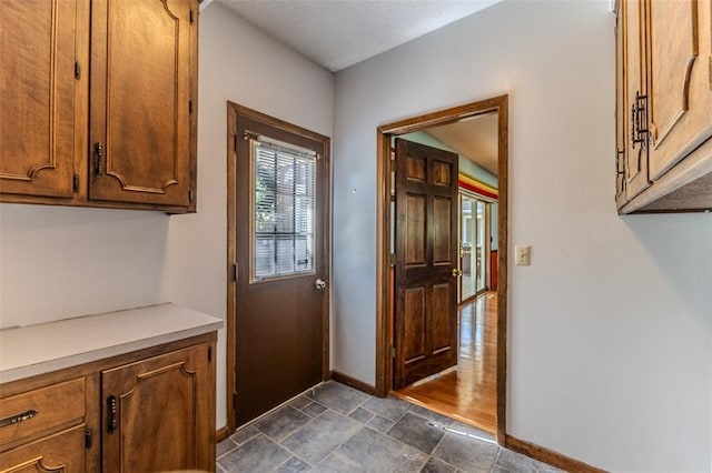 21509 Rockwell Dr, Lebanon, MO 65536 - doorway with baseboards and stone finish floors