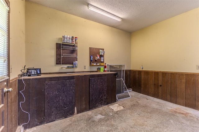21509 Rockwell Dr, Lebanon, MO 65536 - indoor dry bar featuring a wainscoted wall, wooden walls, carpet flooring, and a textured ceiling