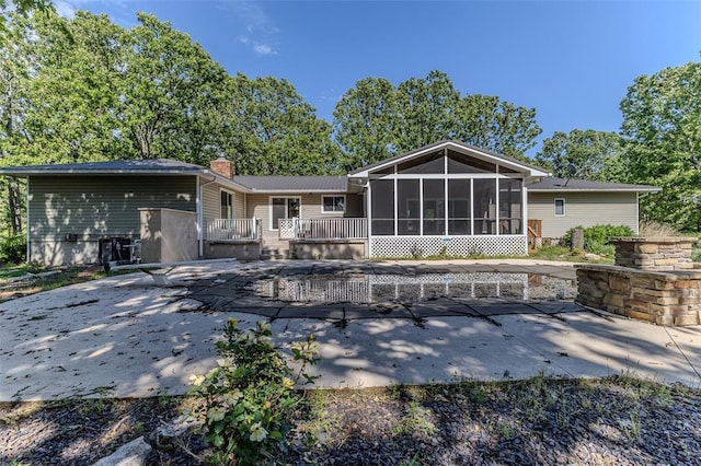 21509 Rockwell Dr, Lebanon, MO 65536 - back of house with a patio area, a sunroom, a chimney, and a wooden deck