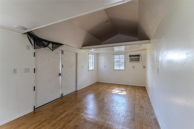 21509 Rockwell Dr, Lebanon, MO 65536 - unfurnished room featuring wood finished floors, an AC wall unit, lofted ceiling, and baseboards